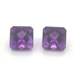 Two Gem Stones in Violet Placed on a White Background